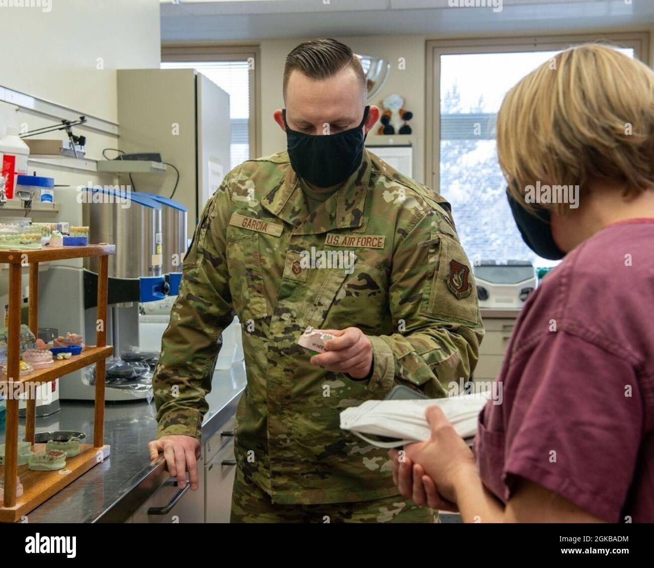 U.S. Air Force Master Sgt. Matthew Garcia, a sinistra, un tecnico di laboratorio dentale assegnato allo squadrone dentale 673d, mostra corone fabbricate al Colon dell'aeronautica degli Stati Uniti Kirsten Aguilar, base del giunto Elmendorf-Richardson e comandante dell'ala della base dell'aria 673d, a JBER, Alaska, 2 marzo 2021. Il tour ha familiarizzato la leadership di base con lo squadrone dentale 673d e il suo ruolo nel supporto della preparazione. Il 673d Dental Squadron offre una gamma completa di cure dentistiche per le forze aeree attive, i partner di missione attivi idonei, i servizi gemellati e i membri militari stranieri. Foto Stock