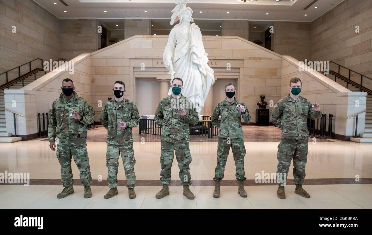 Da sinistra: U.S. Army Master Sgt. Charles Hall, 2 Lt. Eric Daniels, Sgt. Rine Hessel, i Lt. Jennifer Swyfeler, e SPC. Jeremiah Anderson, tutti con la 177a brigata della polizia militare, la Guardia Nazionale del Michigan, posano per una foto con il loro Governatore’s Coin of Excellence nel Campidoglio degli Stati Uniti di Washington, D.C., 5 marzo 2021. La Guardia Nazionale è stata invitata a continuare a sostenere le forze dell'ordine federali con sicurezza, comunicazioni, evacuazione medica, logistica e supporto per la sicurezza alle agenzie statali, distrettuali e federali fino a metà marzo. Foto Stock