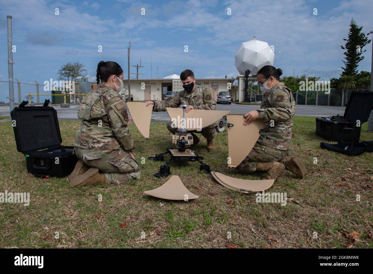 U.S. Air Force Airman 1st Class Monica Batiste, U.S. Air Force Airman 1st Class Benjamin Braund e U.S. Air Force staff Sgt. Manenita Matanguihan, tecnici dei sistemi di trasmissione a radiofrequenza con il 18° Squadrone delle comunicazioni, montano petali a disco su un satellite molto piccolo di aperture Terminal presso la base aerea di Kadena, Giappone, 5 marzo 2021. Il sistema Client Operations Transmissions Flight gestisce anche le quattro antenne satellite geostazionarie Meteorologiche su Kadena. Queste antenne consentono agli esperti di previsioni meteorologiche di mantenere aggiornate le informazioni satellitari per scopi di previsione. Foto Stock
