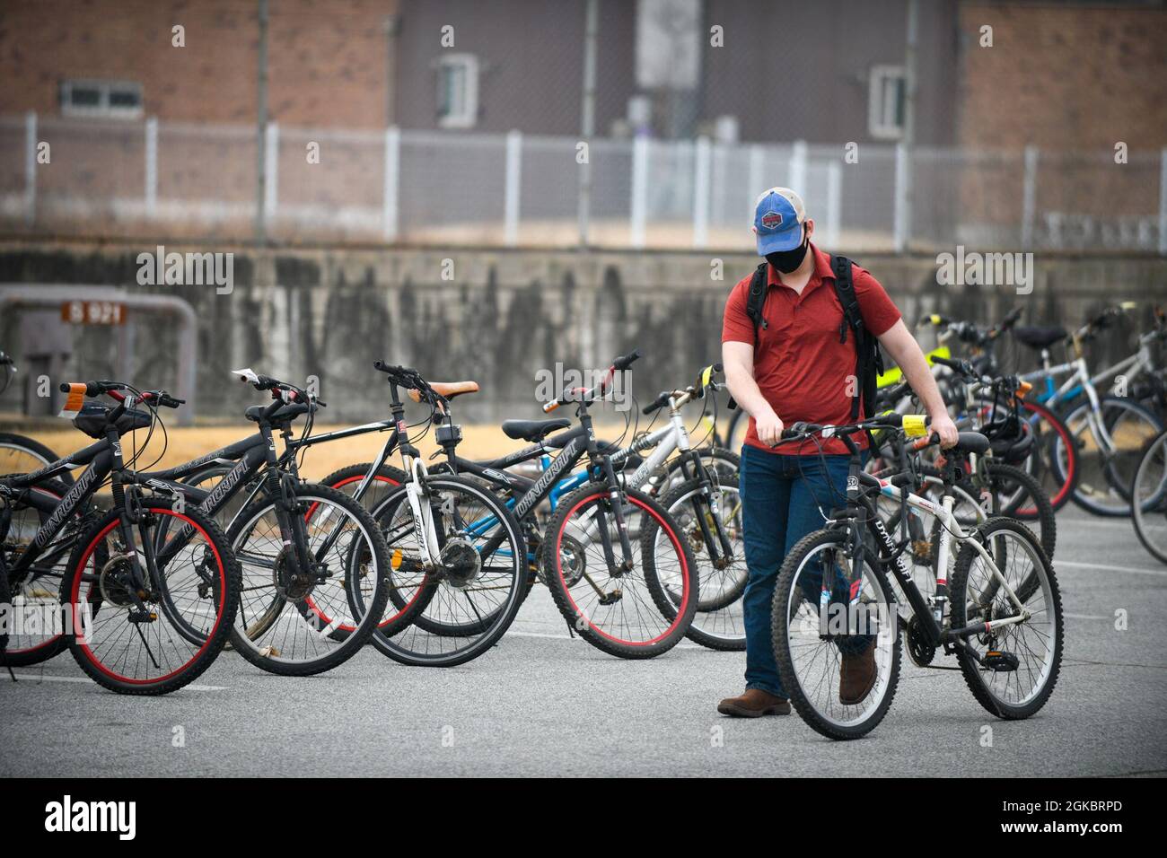 CAMP HUMPHREYS, Repubblica di Corea - Un membro della comunità Humphreys rotola una bicicletta gratuita che ha scelto fino allo stand di registrazione durante la seconda Area III annuale USAG Humphreys Religious Support Office (RSO) Community Bicycle Giveaway here, 6 marzo. L'RSO ha ospitato il omaggio con l'assistenza della polizia militare da tutta Humphreys, fornendo l'opportunità per i membri della comunità di selezionare tra circa 100 biciclette impenetraute e abbandonate e registrarle come proprie. Foto Stock