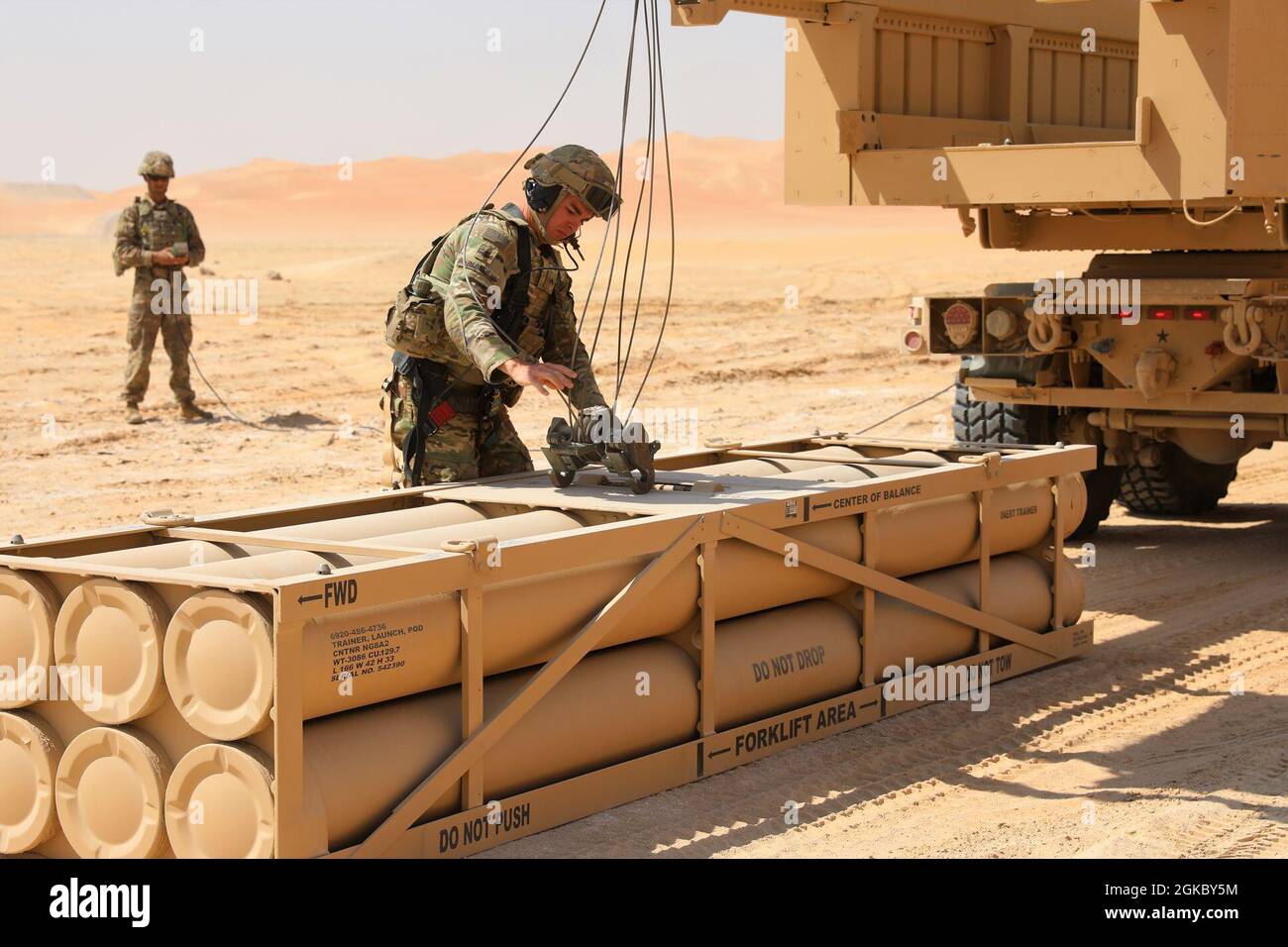 Un membro del Battaglione di artiglieria da campo 1-14 conduce le operazioni di caricamento del sistema di razzo di artiglieria ad alta mobilità durante un esercizio in Medio Oriente Foto Stock