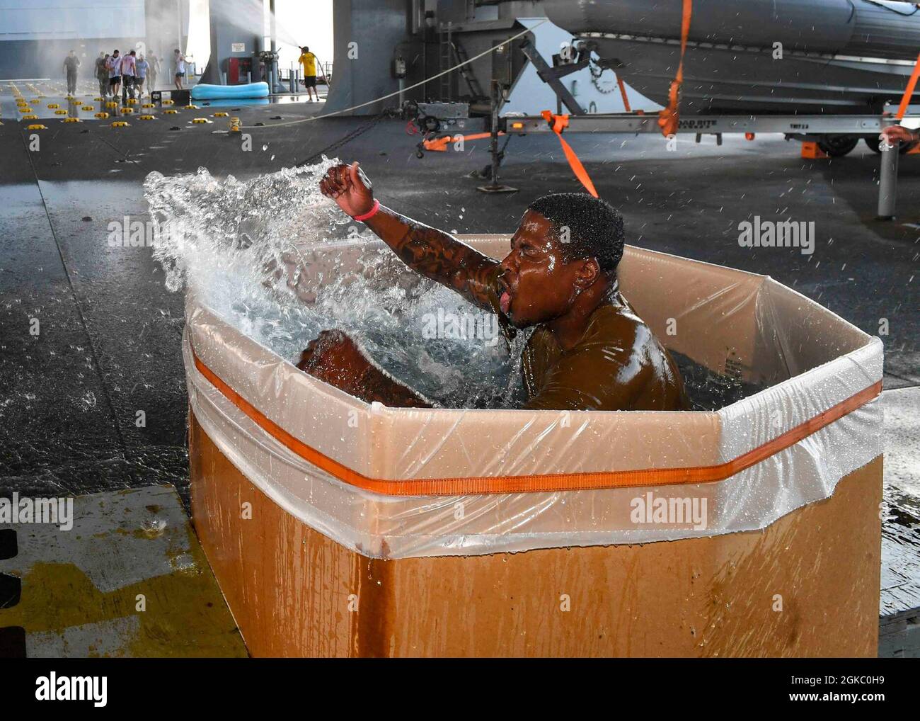 GOLFO DI GUINEA (MAR. 08, 2021) Gunners Mate Seaman Herbert Steadman salta in una pozza d'acqua alla fine di una cerimonia di attraversamento della linea alle coordinate globali 00.00N/00.00W per ottenere lo status di Emerald Shellback a bordo della base del mare di Expeditionary USS Hershel “Woody” Williams (ESB 4) nell'Oceano Atlantico, 08 marzo 2021. Hershel “Woody” Williams opera nella Sixth Fleet statunitense per condurre una formazione di interoperabilità e costruire partnership strategiche con i partner africani. Foto Stock