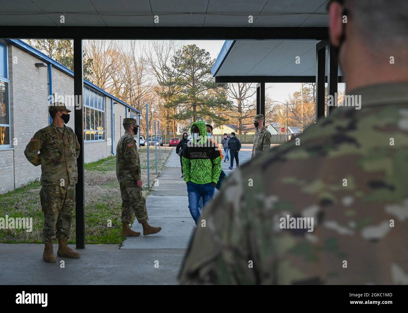 I membri del 128th Aviation Brigade Battaglione 1-222 Regiment Charlie, salutano gli studenti che tornano a scuola al Denbigh High School di Newport News, Virginia, 8 marzo 2021. I membri dell'unità agitavano, salutavano e desideravano agli studenti la fortuna di tornare ai loro studi mentre si allontanavano socialmente. Foto Stock