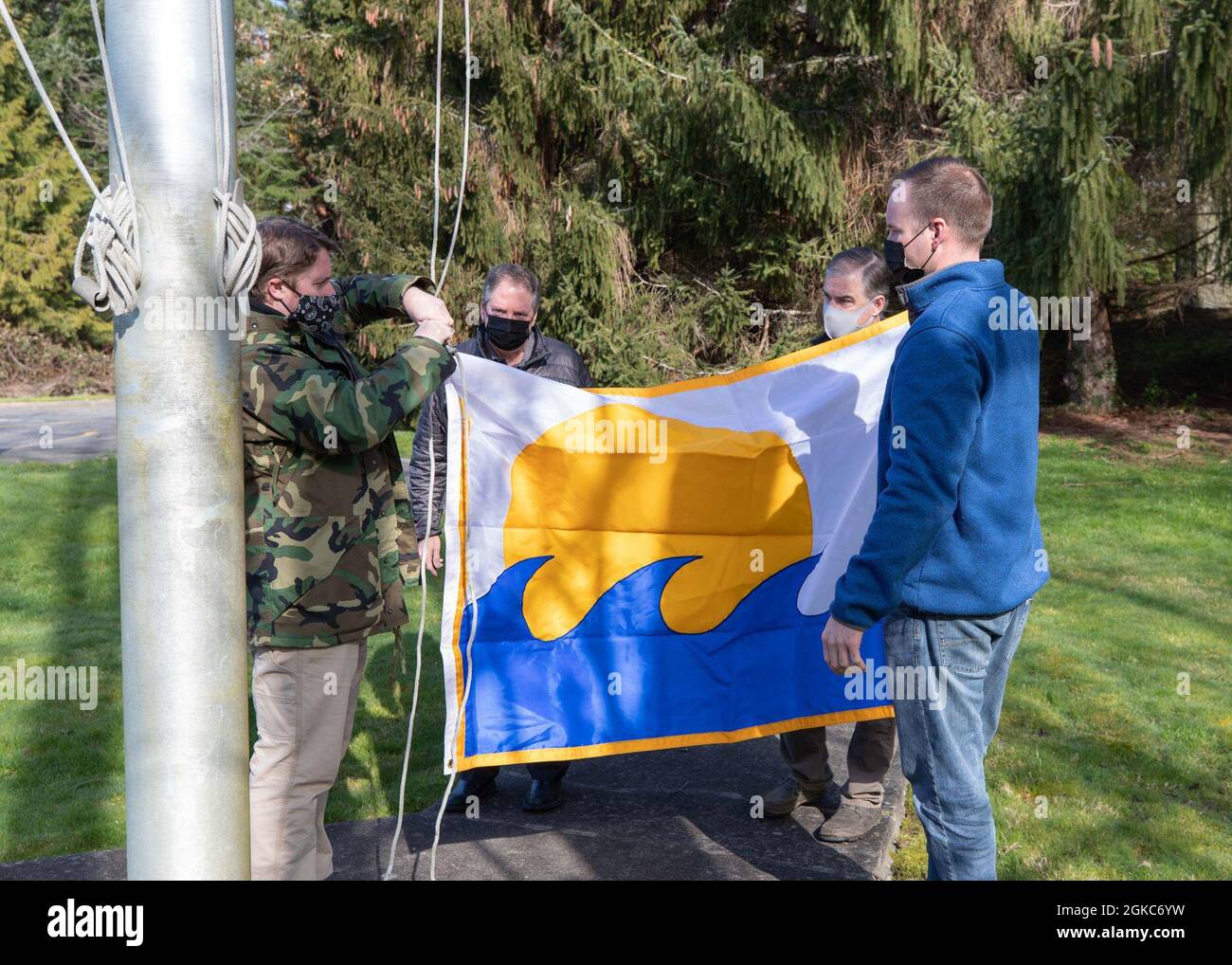210310-N-UV347-008 KEYPORT, Washington (10 marzo 2021) – i membri della Divisione Naval Undersea Warfare Center della Divisione Infrastructure di Keyport si preparano a sollevare il Segretario della Bandiera Navy Energy dopo aver vinto il SECNAV Energy Excellence Award nella categoria Small installation per il 2020. In riconoscimento del risultato, il comando è autorizzato a battere la bandiera per un anno fino all'anniversario della sua data di assegnazione. Il premio è assegnato alle installazioni della Marina che eccellono nella gestione dei programmi energetici, nel contributo alla sicurezza energetica, nel miglioramento della prontezza e nella capacità di missione. Foto Stock