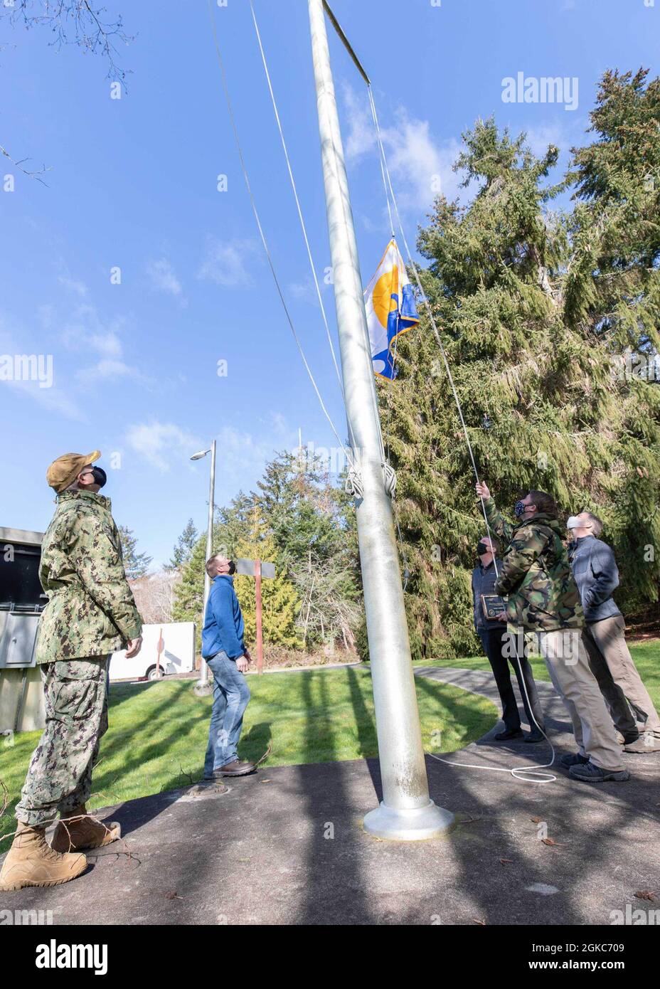 210310-N-UV347-010 KEYPORT, Washington (10 marzo 2021) – i membri della Divisione Naval Undersea Warfare Center Divisione Infrastructure Keyport sollevano il Segretario della Bandiera Navy Energy dopo aver vinto il SECNAV Energy Excellence Award nella categoria Small installation per il 2020. In riconoscimento del risultato, il comando è approvato per volare la bandiera per un anno fino all'anniversario della sua data di assegnazione. Il premio è assegnato alle installazioni della Marina che eccellono nella gestione dei programmi energetici, nel contributo alla sicurezza energetica, nel miglioramento della prontezza e nella capacità di missione. Foto Stock