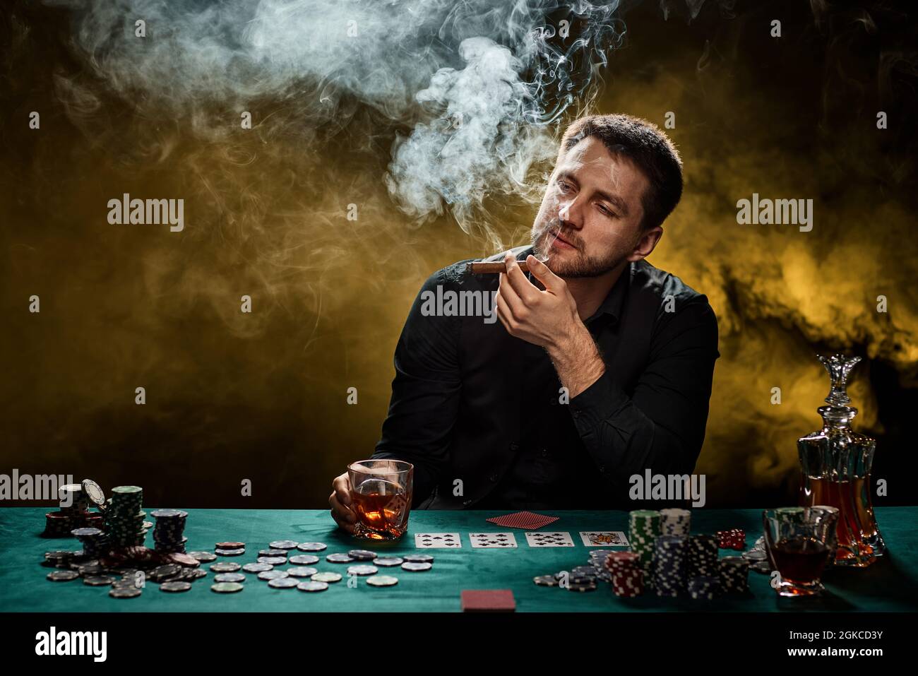 Uomo giocatore di casinò bearded che gioca a poker su tavolo verde Foto Stock