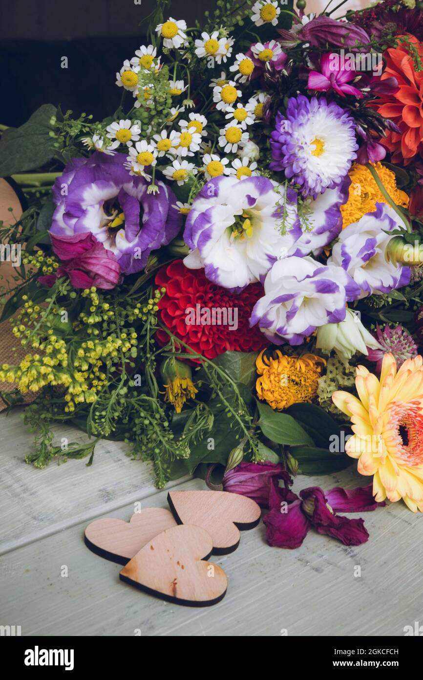 Un bouquet di nozze di fiori estivi con decorazioni cuore d'amore di fronte Foto Stock