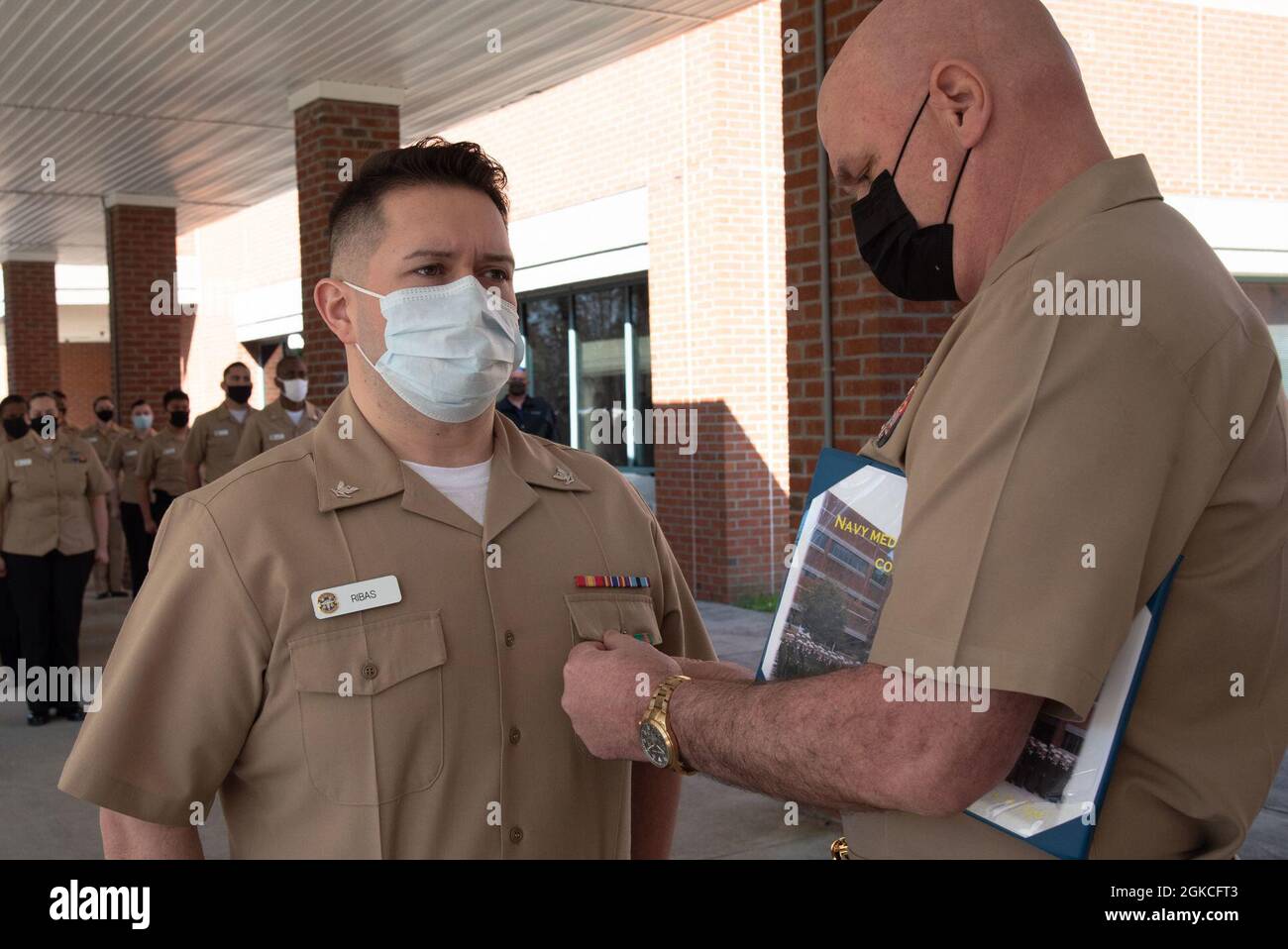 Il capitano Stephen Douglas Stephens, comandante della clinica navale di salute Cherry Point, riconosce l'Hospitalman Marcus Ribas di Sioux Falls, South Dakota, con la medaglia di conquista della Marina e del corpo marino durante una cerimonia a bordo della clinica durante una cerimonia tenuta venerdì 12 marzo 2021. Foto Stock