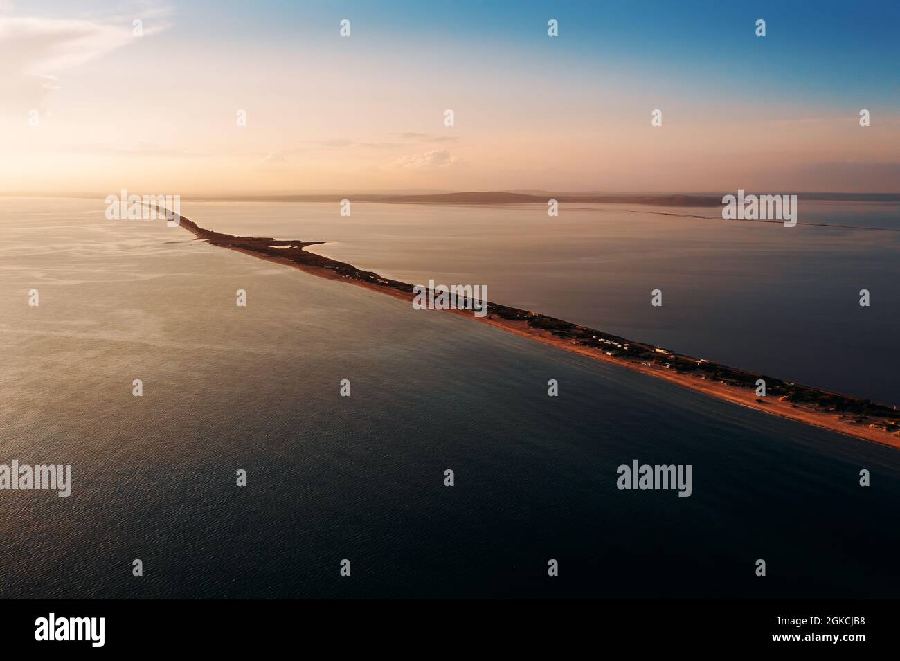 Lungo spit con spiaggia sabbiosa tra mare e liman al tramonto, vista aerea dal drone. Foto Stock