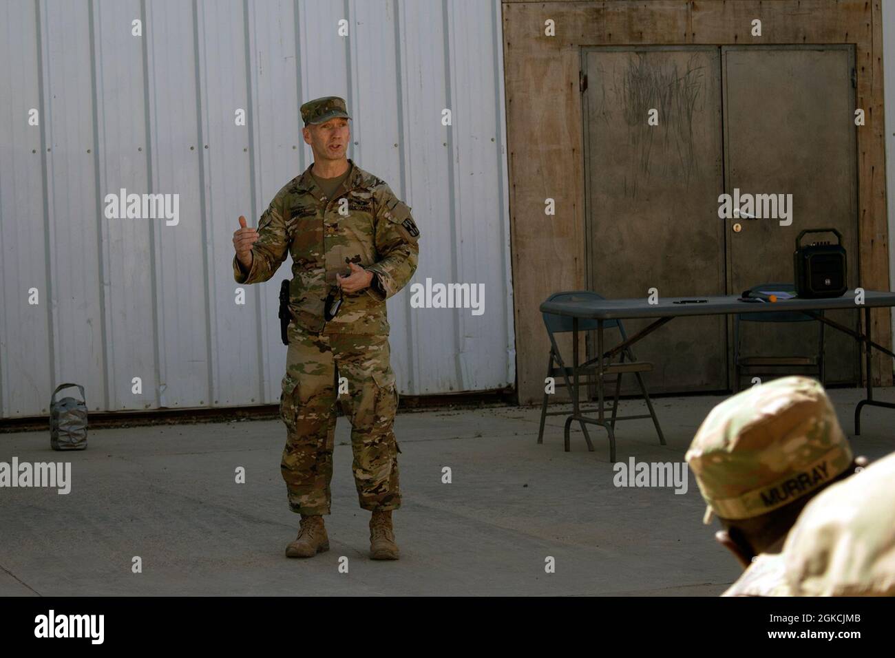 Il Major Jason L. Cossey, comandante del 466th Medical Company Area Support, si rivolge a una folla di membri del servizio degli Stati Uniti, partner di coalizione e appaltatori civili durante un municipio del vaccino COVID-19 il 13 marzo 2021. Un giorno prima che la base ricevesse la sua prima spedizione di vaccini COVID-19, lo staff di Role II e la leadership di al Asad tenevano un secondo municipio per fornire informazioni sulla sicurezza e l'efficacia del vaccino e domande sul campo da parte dei residenti di al Asad. Foto Stock