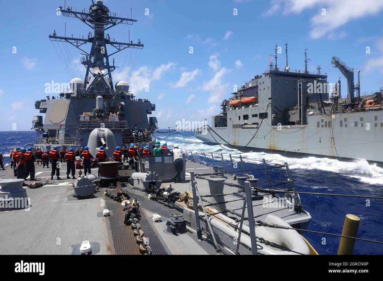 Il cacciatorpediniere missilistico guidato di classe Arleigh Burke USS Benfold (DDG 65) conduce un rifornimento in mare con la nave da carico a secco di classe Lewis e Clark USNS Charles Drew (T-AKE 10). Benfold è assegnato alla Task Force 71/Destroyer Squadron (DESRON) 15, il più grande DESRON schierato in avanti della Marina e la principale forza di superficie della 7a flotta statunitense. Foto Stock