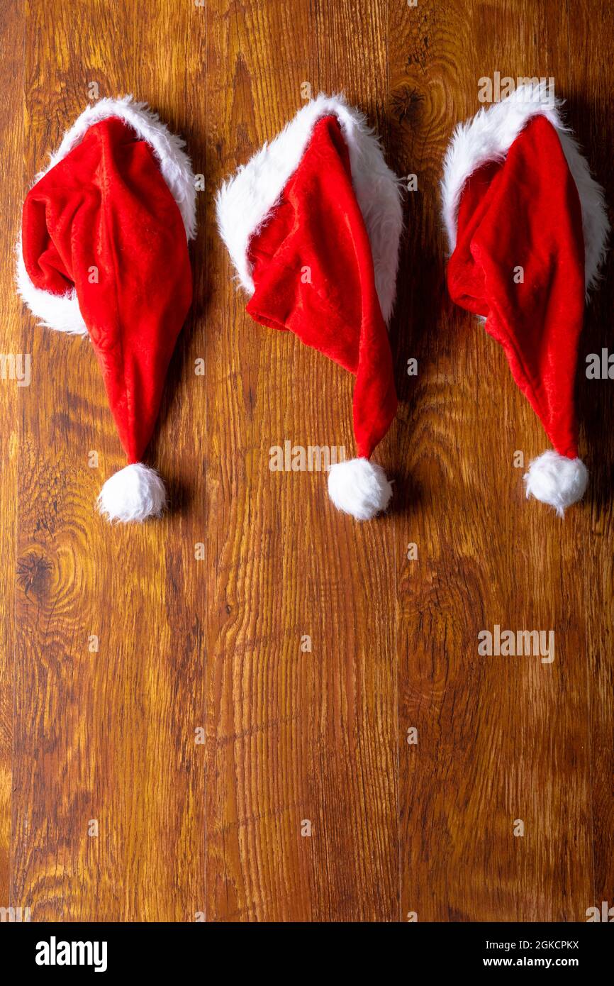 Composizione di cappelli babbo natale e spazio copia su sfondo di legno Foto Stock