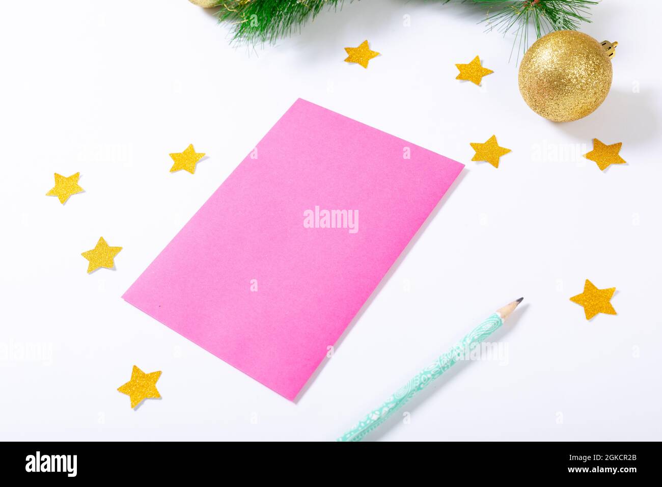 Composizione di cartoncino rosa con spazio per la copia, stelle, matita e bauble su sfondo bianco Foto Stock