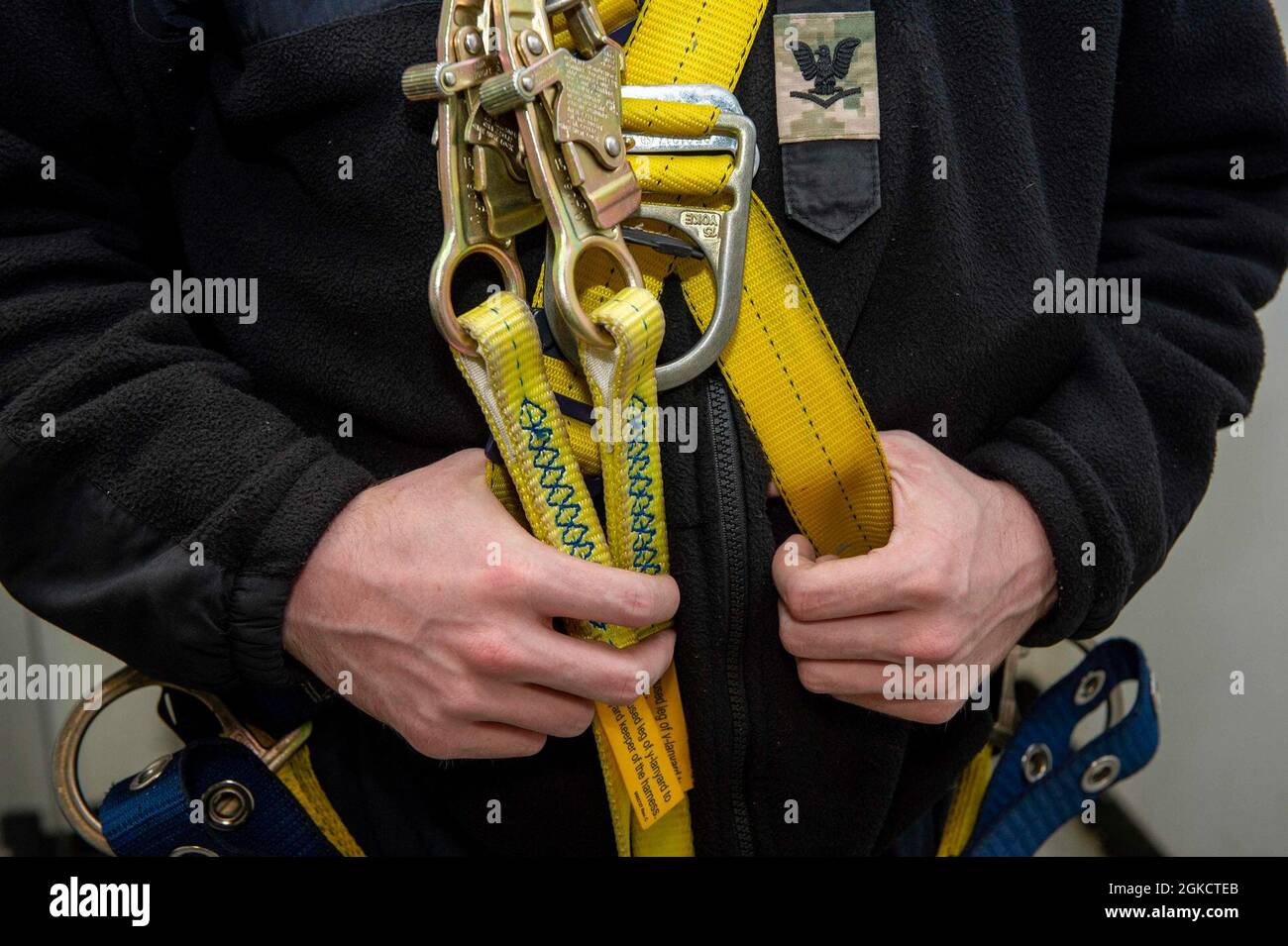 210315-N-EH998-1116 PORTSMOUTH, Va. (15 marzo 2021) Interior Communications Electrician 3rd Class Wilson Christian, di Houston, afferra un'imbracatura a bordo della portaerei USS George H. W. Bush (CVN 77). GHWB è attualmente a Norfolk Naval Shipyard per il suo docking pianificato Incremental Availability. Foto Stock