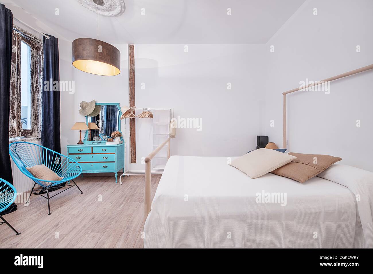 Dormitorio en apartamento vacacional con tocador azul y butacas azules. Decoracion chic para viajeras. Foto Stock