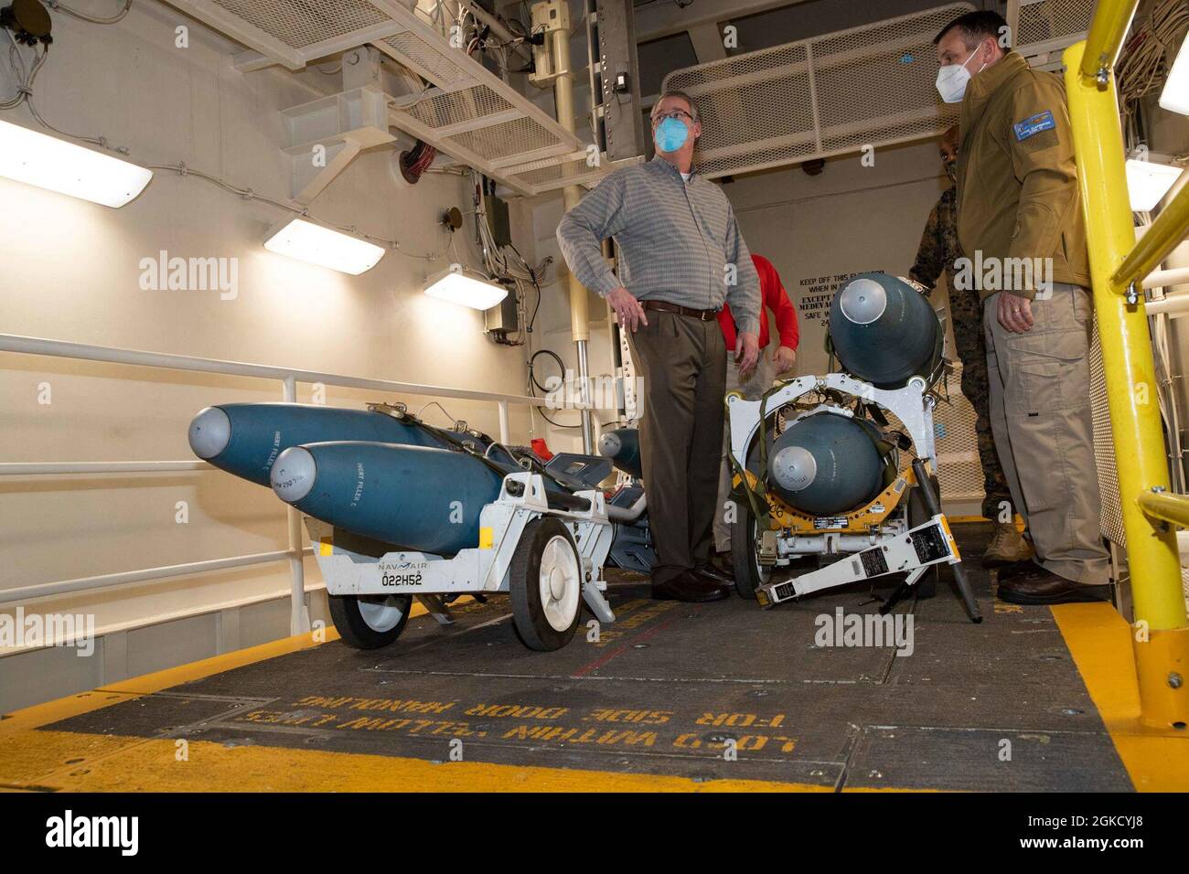 Segretario di Stato della Marina (SECNAV) l'onorevole Thomas W. Harker, a sinistra, ascolta un breve intervento da parte di Racc. Craig Clapperton, comandante, Carrier Strike Group 12, sulle capacità avanzate di ascensore delle armi in USS Gerald R. Ford (CVN 78) armi che gestiscono l'area di trasferimento durante un tour della nave, 16 marzo 2021. Durante la sua visita, Harker ha incontrato i leader senior per discutere le capacità uniche di Ford e Ford-class, così come i risultati chiave per la sua prontezza operativa. Ford è in corso nell'Oceano Atlantico che conduce le qualifiche del vettore. Foto Stock