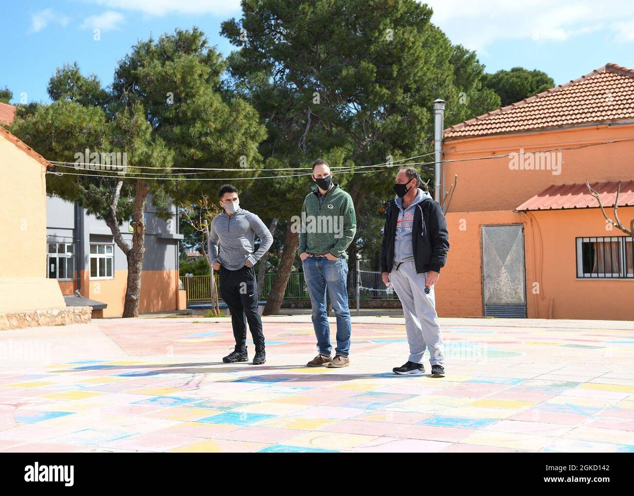 CHANIA, Creta (16 marzo 2021) Utilitiesman III Classe Dodanin Agumedo, Lt. Michael ha parlato, un cappellano della Marina, e Yannis Kalitsakis, presidente dell’associazione dei genitori della Scuola elementare di Pazinos, parlano della storia della scuola elementare Mar. 16, 2021, a Chania, Creta, Grecia. I marinai presenti a bordo dell'attività di supporto navale di Souda Bay partecipano regolarmente a progetti di servizio comunitario per promuovere buone relazioni tra la Grecia e gli Stati Uniti. Foto Stock
