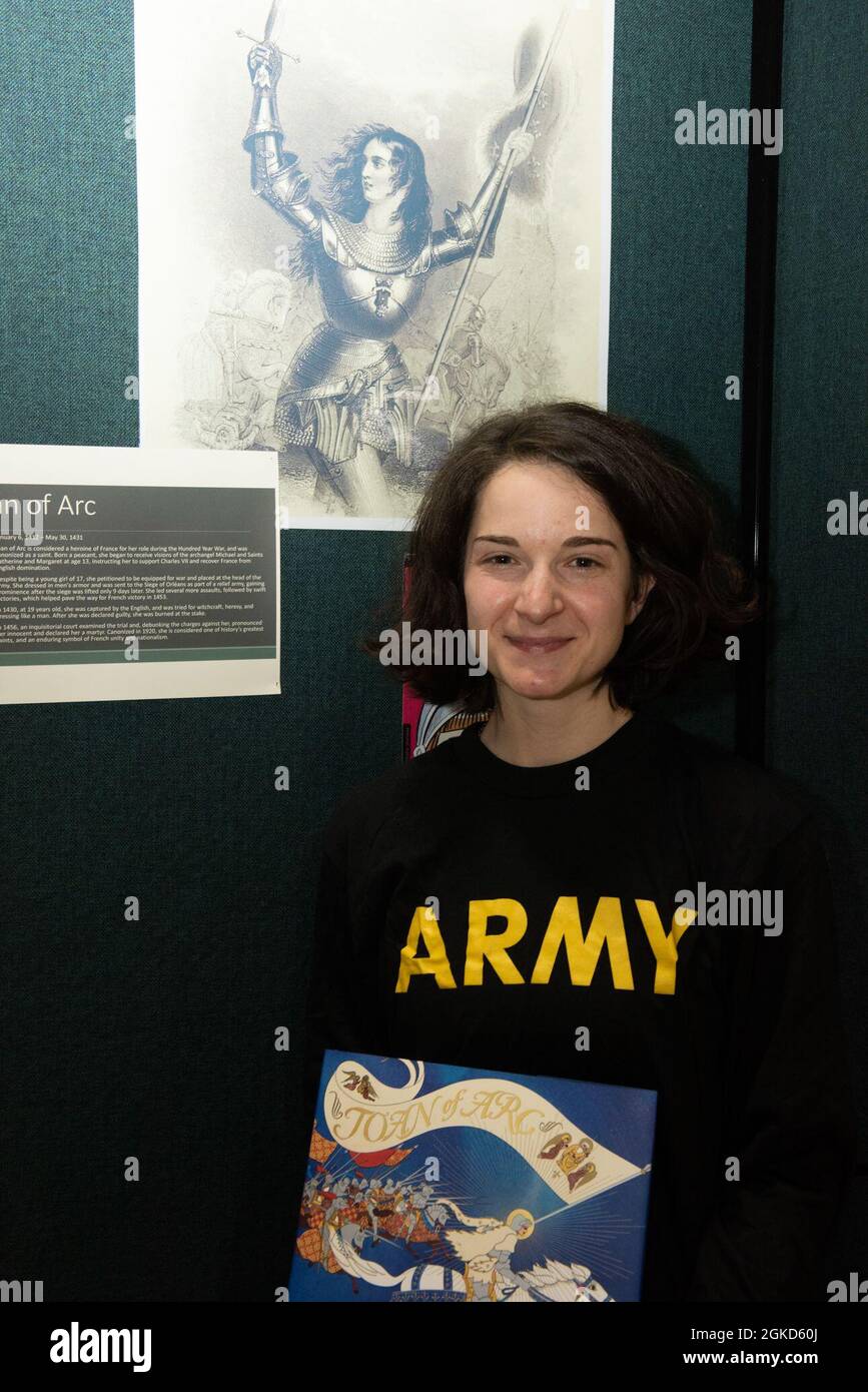 Personale dell'esercito Sgt. Samantha Fontaine pone per una foto di fronte a una mostra di Giovanna d'Arco nella Green Mountain Armory a Camp Johnson, Vermont, 18 marzo 2021. Fontaine, un servizio di pensionamento NCO con sede centrale della forza congiunta - Guardia Nazionale dell'Esercito del Vermont, era uno dei diversi Guardswomen che ha facilitato una lettura del libro e l'esposizione delle uniformi e delle attrezzature della Guardia via teleconferenza per un centro locale di cura di giorno. Foto Stock