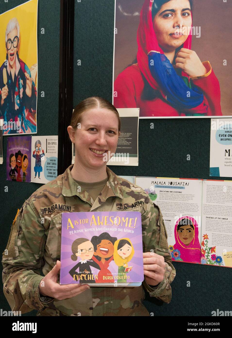 Il Chief Warrant Officer 2 Megan Passamoni pone di fronte ad una mostra di Malala Yousafzai nella Green Mountain Armory a Camp Johnson, Vermont, 18 marzo 2021. Passamoni, tecnico delle risorse umane presso la sede della Guardia Nazionale dell'Esercito del Vermont, 86a squadra di combattimento di Brigata di fanteria (montagna), è stato uno dei numerosi Guardswomen che ha facilitato la lettura e l'esposizione di un libro di uniformi e attrezzature della Guardia per un centro di cura locale. Foto Stock
