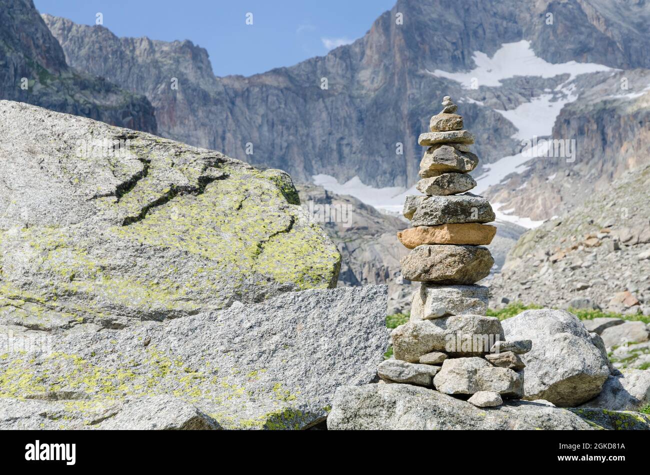 Cumulo di rocce e ciottoli che simboleggiano equilibrio e stabilità lungo un sentiero escursionistico con catena montuosa nelle alpi svizzere, in Svizzera, CH, in Europa Foto Stock