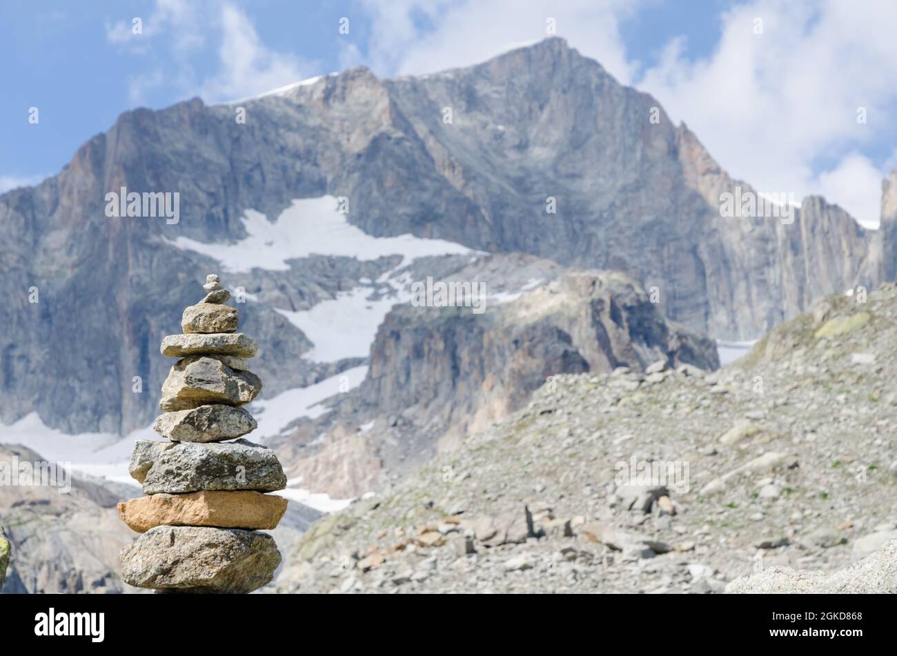Cumulo di rocce e ciottoli che simboleggiano equilibrio e stabilità lungo un sentiero escursionistico con catena montuosa nelle alpi svizzere, in Svizzera, CH, in Europa Foto Stock
