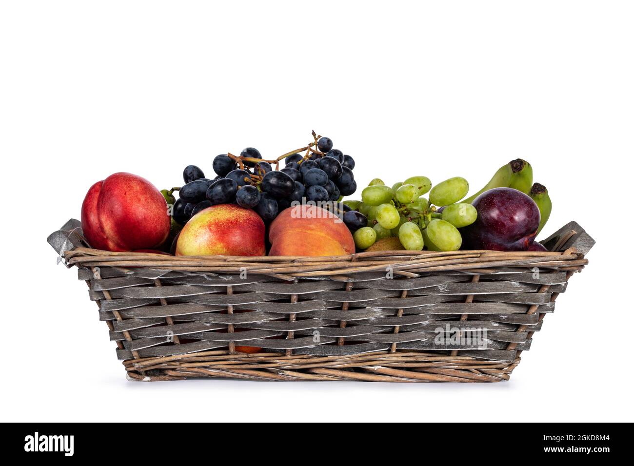 Cestino di frutta intrecciato con una varietà di frutta in esso. Isolato su sfondo bianco. Foto Stock
