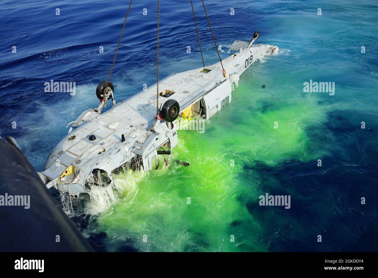 NORTH PACIFIC OCEAN 19 marzo 2021 un MH-60S che si è schiantato in mare nel gennaio 2020 libera la superficie dopo un assenso di nove ore da profondità record. Il marcatore di colore marino dai sacchi di ricerca e recupero con registrazione ad acqua (SAR) degli aeromobili si sciacquano verso il mare durante un'operazione di recupero a marzo. 19, 2021. I marcatori di colorante marini sono un'alternativa sicura ed efficace alle svasature e al fumo per le operazioni SAR. L'operazione di recupero, coordinata dagli investigatori del centro di sicurezza navale (NAVSAFECEN) e dal Supervisore di Salvage e Diving, offre l'opportunità agli investigatori NAVSAFECEN di esaminare le critiche Foto Stock