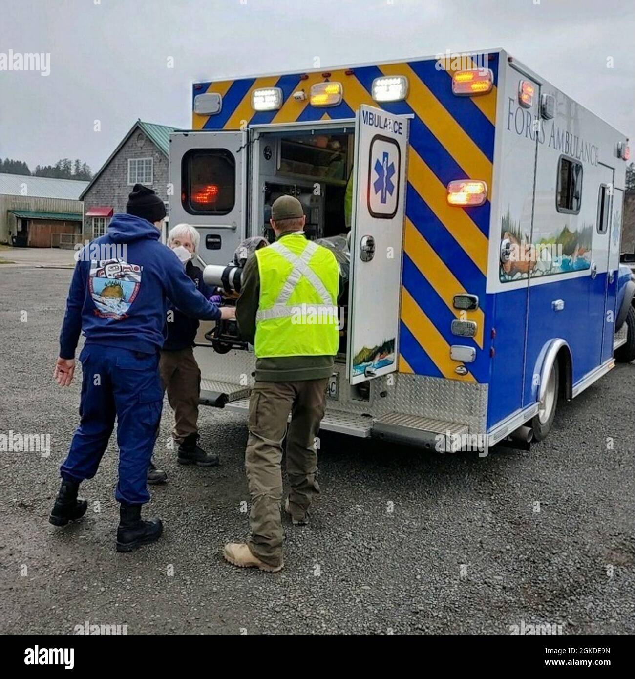 I membri della stazione della Guardia Costiera Quillayute River aiutano un uomo ad un'ambulanza in attesa dopo che la nave era in affondato il 20 marzo 2021, a cinque miglia al largo della costa di la Push, Washington. Nessuno degli uomini indossava giubbotti di salvataggio. Foto Stock