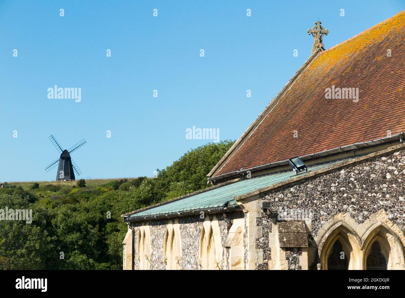 Vista su Rottingdean verso Beacon Mill (nuovo Mulino) sulla collina, visto dal cimitero della Chiesa di San Margarets. Rottingdean, Regno Unito (127) Foto Stock