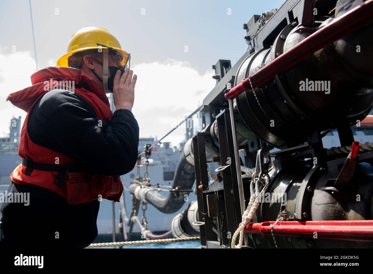 OCEANO PACIFICO (22 marzo 2021) — Mark Kriston, di Boatswain, di Rutherford, N.J., trasmette istruzioni durante un rifornimento in mare tra il molo di trasporto anfibio di classe San Antonio USS Portland (LPD 27) e la nave da carico a secco di classe Lewis e Clark USNS Richard E. Byrd (T-AKE 4). Portland sta conducendo operazioni di routine nella terza flotta degli Stati Uniti. Foto Stock