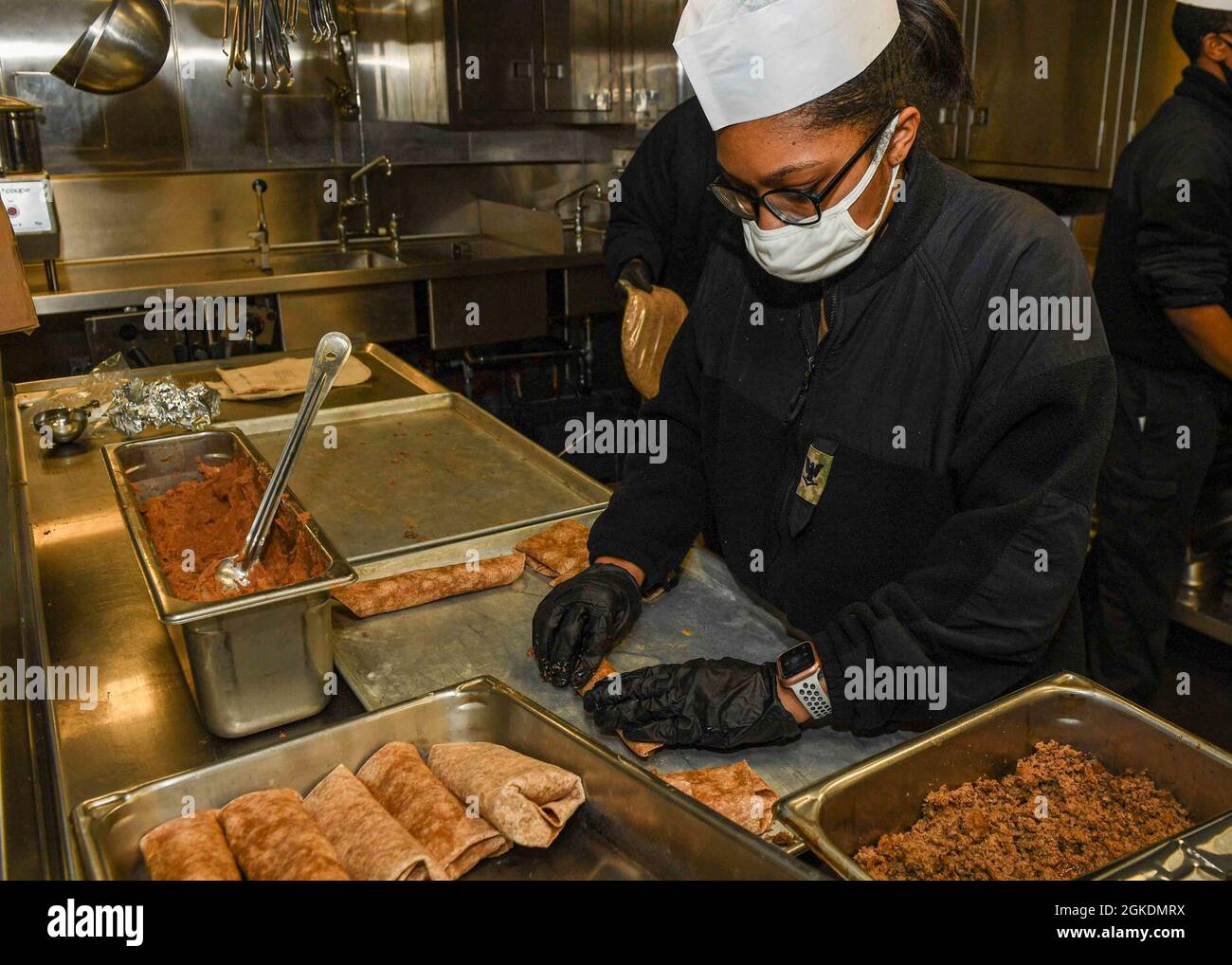 OCEANO ATLANTICO (Mar. 23, 2021) Specialista culinario terza classe Janea Coleman prepara il pranzo in cucina a bordo della base del mare di Expeditionary USS Hershel “Woody” Williams (ESB 4) Oceano Atlantico, 23 marzo 2021. Hershel “Woody” Williams opera nella Sixth Fleet statunitense per condurre una formazione di interoperabilità e costruire partnership strategiche con i partner africani. Foto Stock