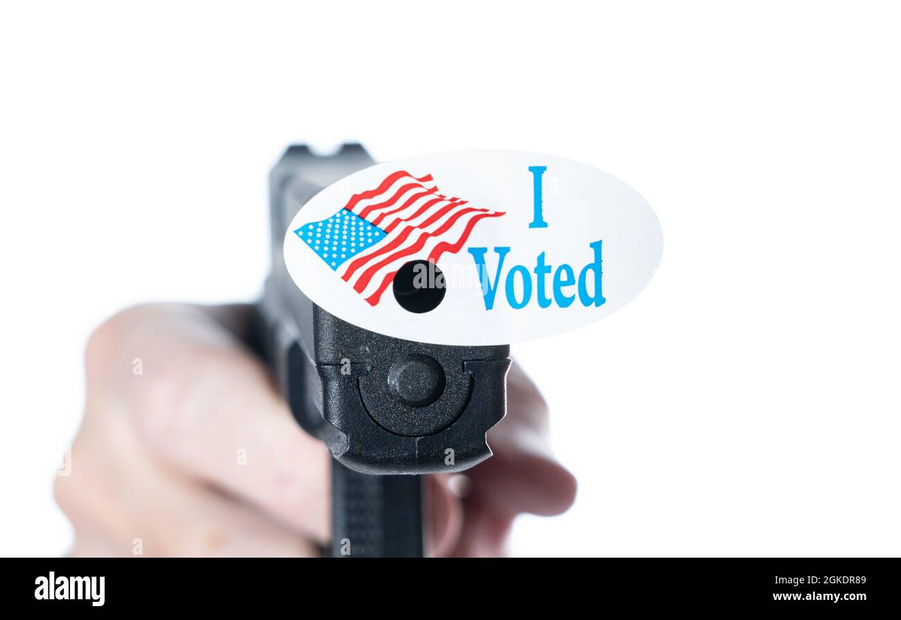 Concetto per la violenza elettorale con pistola decorata con ho votato oggi adesivo con buco fatto da proiettile sparato Foto Stock