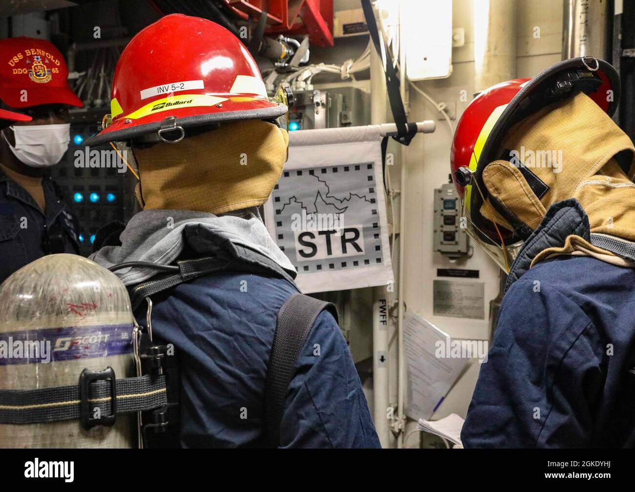 I marinai a bordo del cacciatorpediniere missilistico guidato di classe Arleigh Burke USS Benfold (DDG 65) partecipano a un esercizio di addestramento per il controllo dei danni. Benfold è assegnato alla Task Force 71/Destroyer Squadron (DESRON) 15, il più grande DESRON schierato in avanti della Marina e la principale forza di superficie della 7a flotta statunitense. Foto Stock
