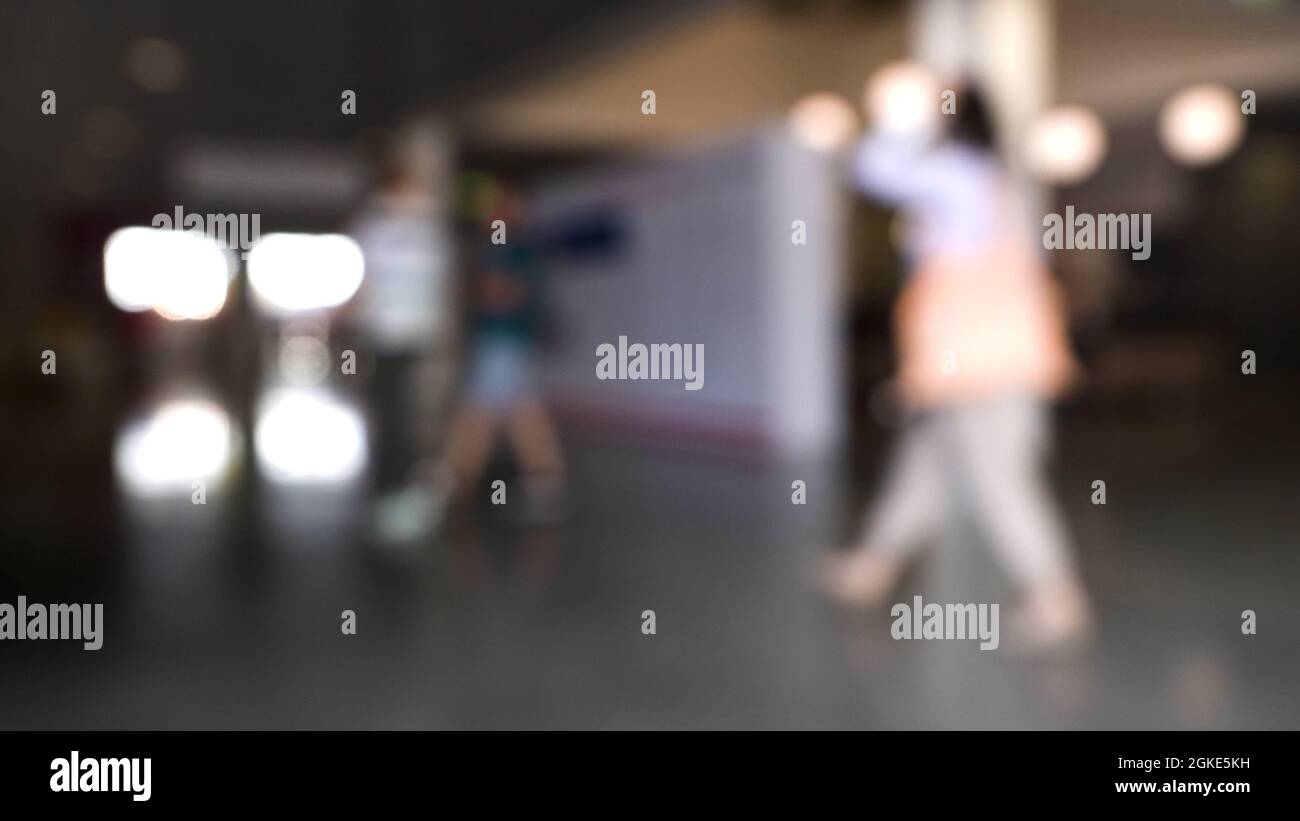 La folla ha defocusato di gente che cammina nel centro commerciale. HDR. Vista offuscata all'interno del business center con uomini e donne che camminano Foto Stock