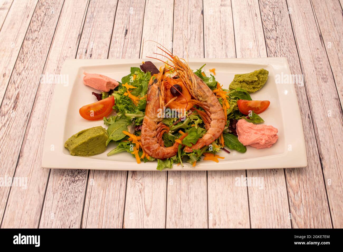 insalata di fusione di avocado, crema di fragole, carota e germogli di lattuga assortiti e gamberi alla griglia Foto Stock