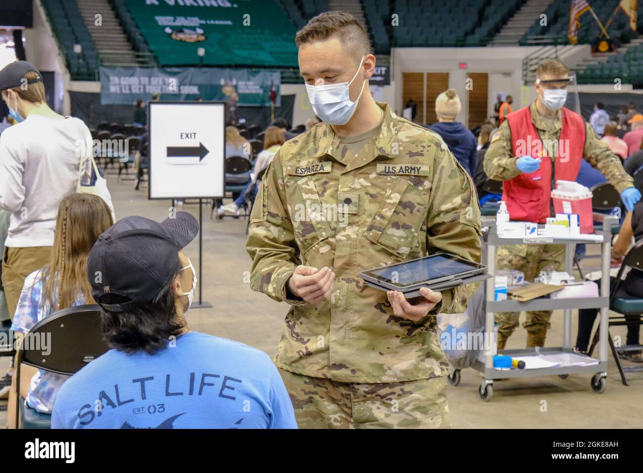 SPC dell'esercito degli Stati Uniti. Omar Esparza, nativo di Newark, Ohio, e membro della squadra di difesa missilistica della 174th Air Defense Artillery Brigade, Ohio National Guard, pone domande sullo screening dei vaccini a un membro della comunità presso il Wolstein Community Vaccination Center, gestito dallo stato, a Cleveland, 27 marzo 2021. La revisione delle domande di screening consente al personale medico di garantire la sicurezza di coloro che ricevono il vaccino. Il comando del Nord degli Stati Uniti, attraverso l'esercito del Nord degli Stati Uniti, rimane impegnato a fornire il supporto continuo e flessibile del Dipartimento della Difesa al Federal Emergency Management Agen Foto Stock