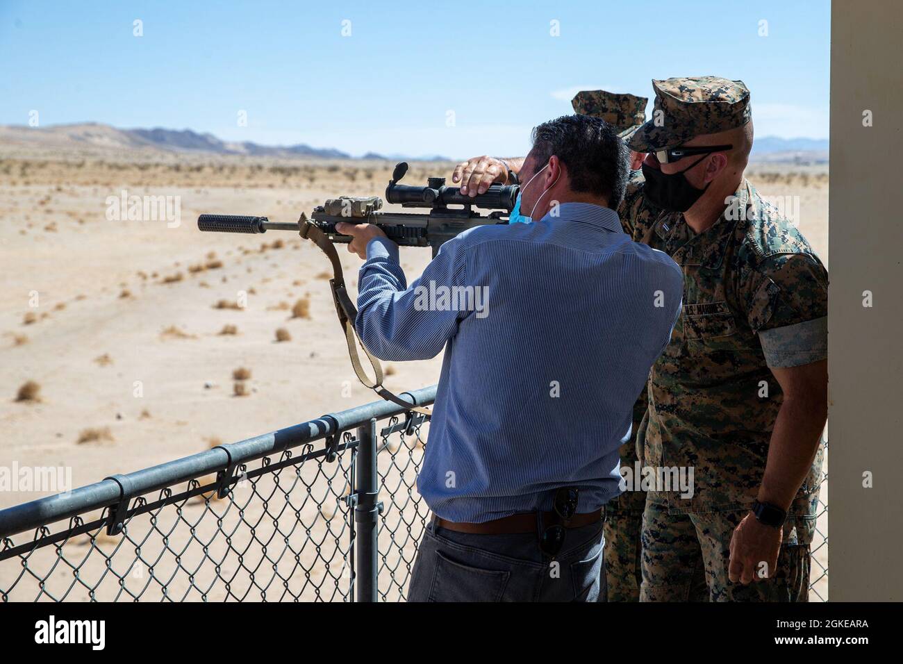 US Marine Corps Chief Warranty Officer 5 Raymond Browne, gunner, Marine Air Ground Task Force Training Command, mostra a Rep. Pete Aguilar, California 31st District Representative, come tenere un fucile automatico di fanteria M27 al Marine Corps Air Ground Combat Center, Twentynine Palms, California, 29 marzo 2021. Aguilar ha parlato con la direzione del Combat Center e ha fatto un giro in diversi campi di allenamento. Foto Stock