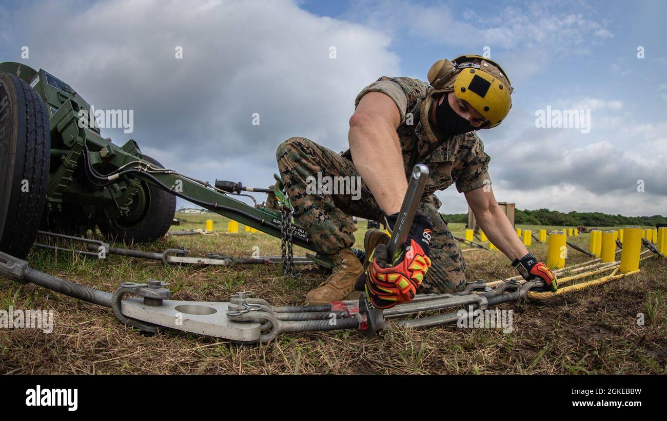 US Marine Corps Lance CPL. Justin Long, un tecnico del campo aereo di spedizione con Marine Wing Support Squadron (MWSS) 172, stringe un tenditore su un sistema di ingranaggi di arresto del corpo marino M-31 come parte di una valutazione di preparazione al combattimento del corpo marino sulla base aerea del corpo marino Futenma, Okinawa, Giappone, 29 marzo 2021. MCCRE è una valutazione che verifica la capacità di un'unità di svolgere le proprie attività essenziali e deve essere completata prima della distribuzione o ogni due anni. Foto Stock