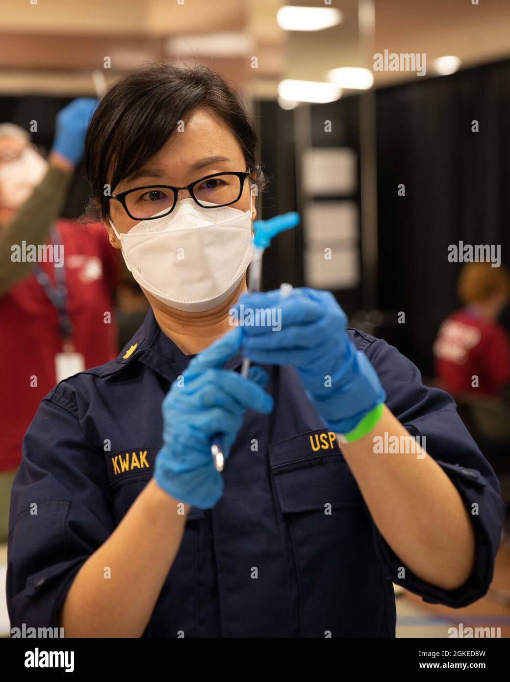 U.S. Public Health Service Lt. CMdR. Jina Kwak, un farmacista, esegue controlli di qualità durante una soft opening presso il COVID-19 Community Vaccination Center, gestito a livello federale, a Norfolk, Virginia, il 30 marzo 2021. Il comando del Nord degli Stati Uniti, attraverso l'Esercito del Nord degli Stati Uniti, rimane impegnato a fornire un supporto continuo e flessibile del Dipartimento della Difesa all'Agenzia federale di gestione delle emergenze come parte della risposta dell'intero governo al COVID 19. Foto Stock