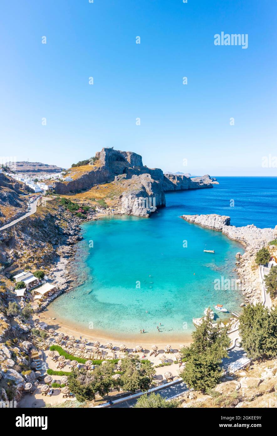 Mare turchese e spiaggia sabbiosa, Acropoli di Lindos, antica cittadella su una scogliera ripida, Lindos, Rodi, Dodecaneso, Grecia Foto Stock