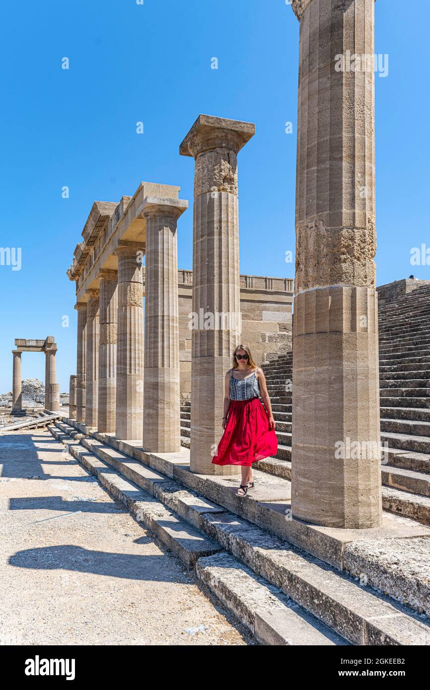 Giovane donna con abito rosso, Acropoli di Lindos, antica cittadella, Lindos, Rodi, Dodecaneso, Grecia Foto Stock