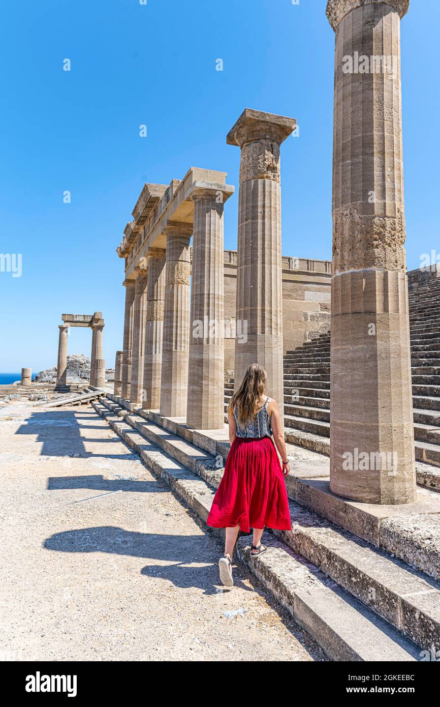 Giovane donna con abito rosso, Acropoli di Lindos, antica cittadella, Lindos, Rodi, Dodecaneso, Grecia Foto Stock