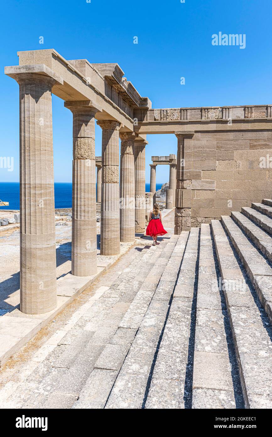 Giovane donna con abito rosso, Acropoli di Lindos, antica cittadella, Lindos, Rodi, Dodecaneso, Grecia Foto Stock