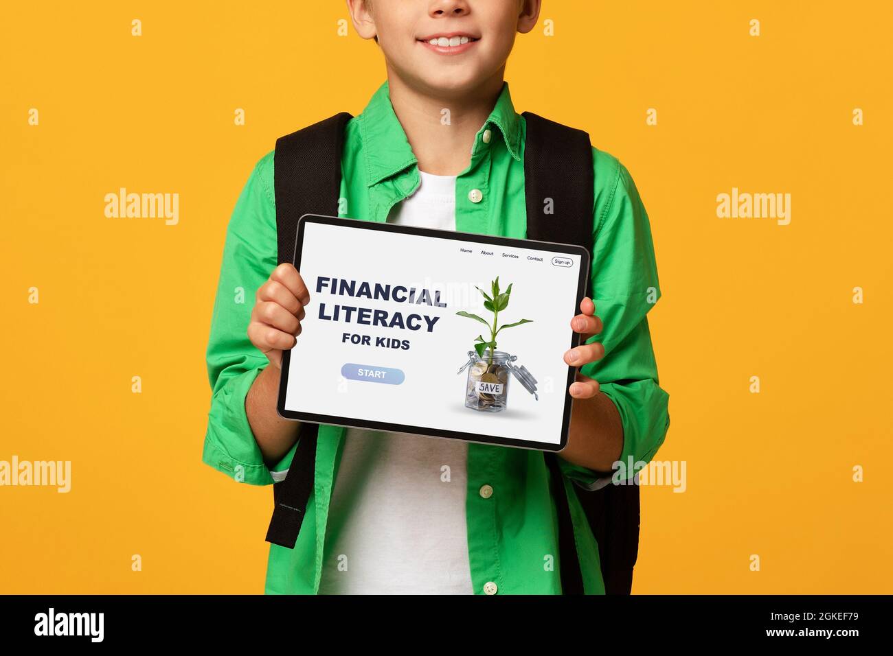 Ragazzo irriconoscibile che mostra tablet con il sito web di alfabetizzazione finanziaria per bambini, pubblicità online educazione economica Foto Stock