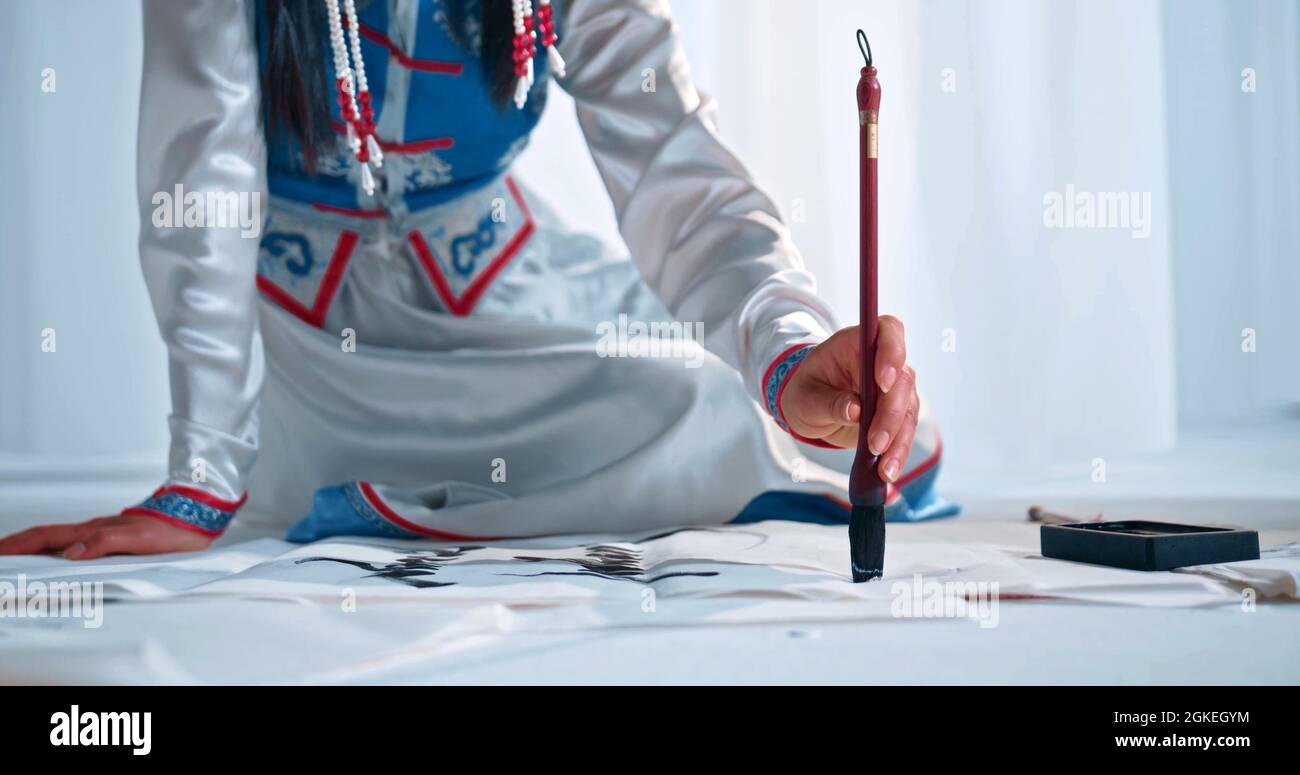 Una donna sta dipingendo una calligrafia cinese Foto Stock