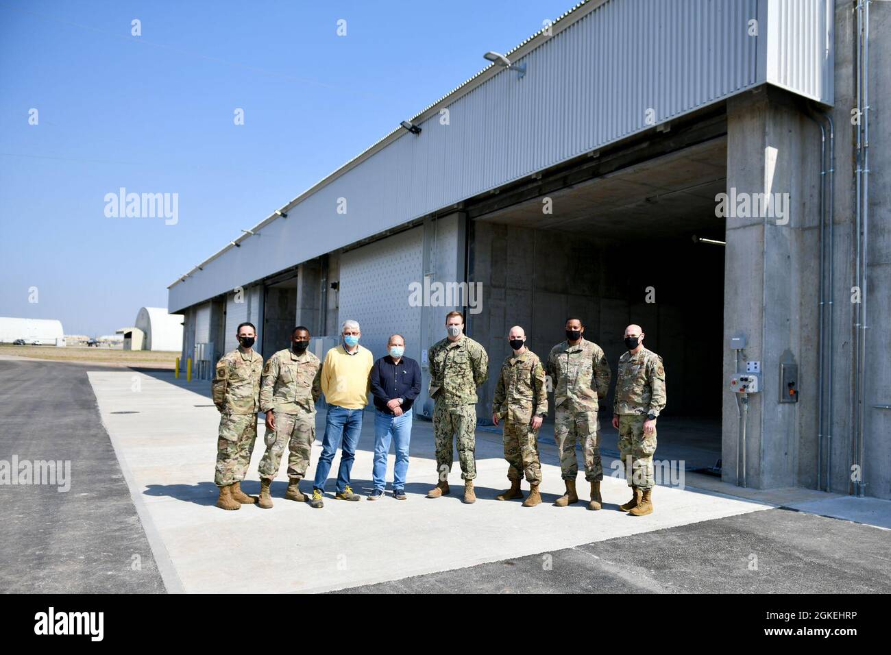 U.S. Air Force, U.S. Navy e il personale addetto al contracting, insieme alla leadership di 31st Fighter Wing, si trovano davanti a tre nuovi moduli di stoccaggio per munizioni coperte da terra nell'Area F della Aviano Air base, Italia, 31 marzo 2021. La pianificazione dei moduli è iniziata nel 2014, con lavori di costruzione a partire da marzo 2020 e terminati un anno dopo. Foto Stock