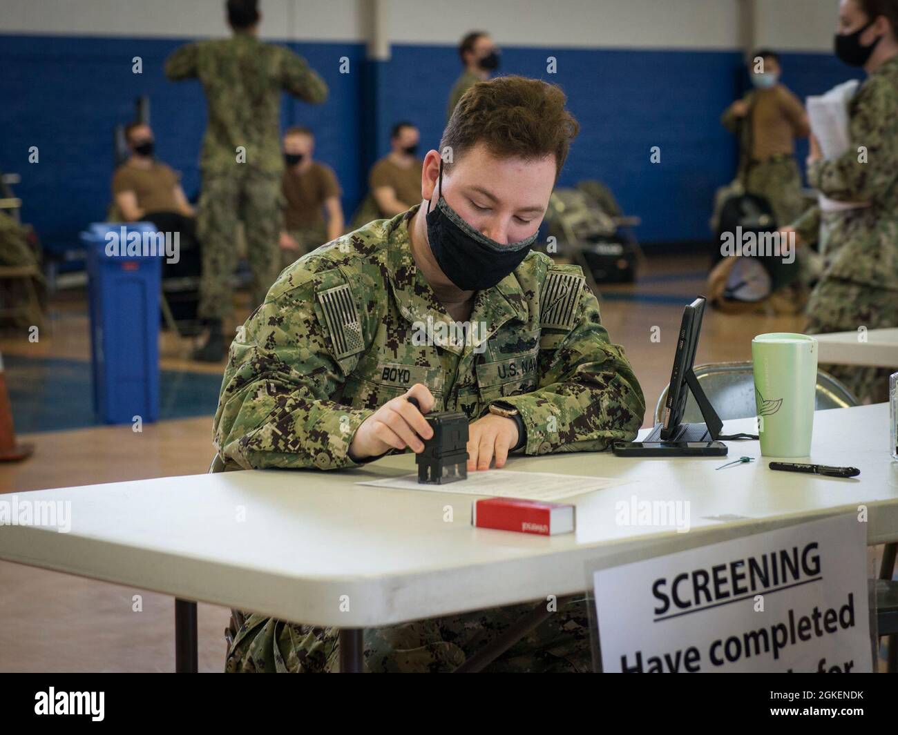 Ospedale Corpsman terza classe Corey Boyd timbra un modulo di screening paziente durante una clinica di vaccinazione alla Morton Hall Gym alla base navale sottomarina New London a Groton, Connecticut, 1 aprile 2021. La Guardia Nazionale del Connecticut ha collaborato con la base per distribuire ulteriormente i vaccini Pfizer COVID-19 a circa 1,000 marinai e personale Navale idoneo. Foto Stock