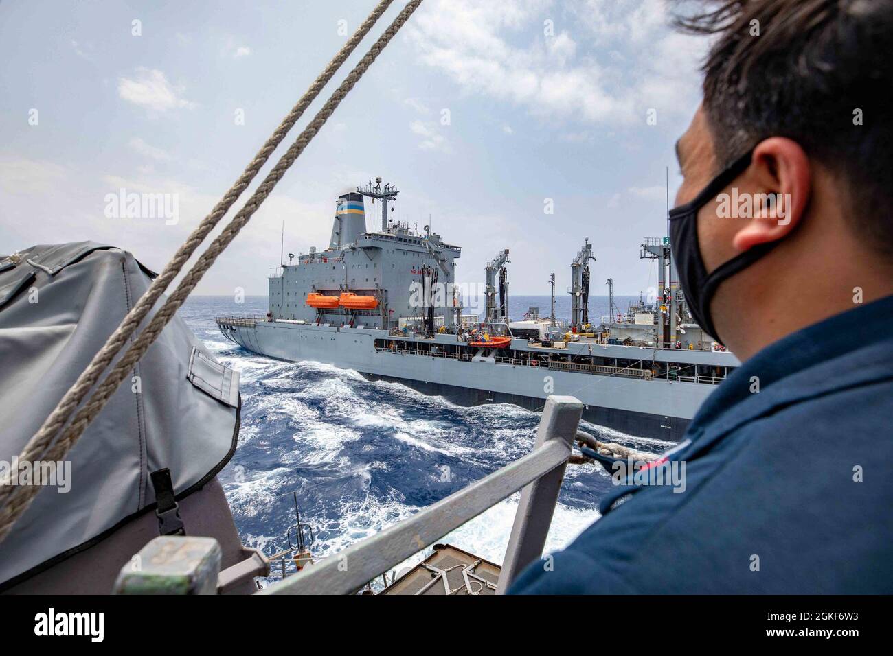 SOUTH CHINA SEA (06 aprile 2021) - il cacciatorpediniere missilistico guidato di classe Burke di Arleigh USS Barry (DDG 52) conduce un rifornimento in mare con una nave da carico secca di classe Lewis e Clark USNS Pecos. Barry è assegnato alla Task Force 71/Destroyer Squadron FIFTEEN (DESRON 15), la più grande DESRON dispiegata in avanti della Marina e la principale forza di superficie della 7a flotta statunitense. Foto Stock