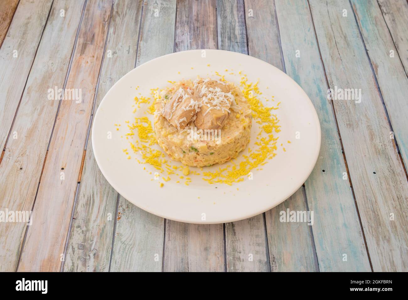 Tapa spagnola di insalata russa con tonno e uova grattugiate su piatto bianco Foto Stock