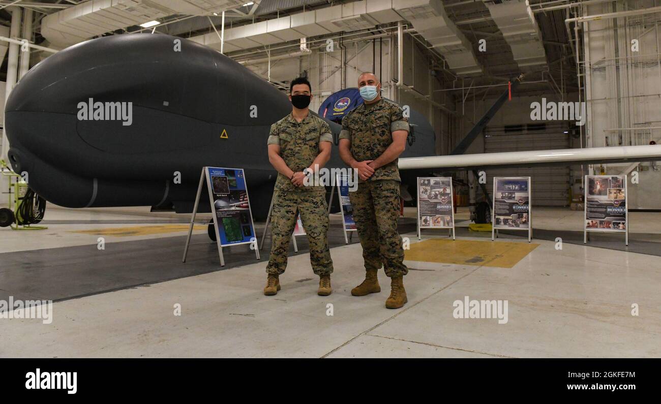 Il capitano Thomas Dioguardi, a sinistra, l'ufficiale delle collezioni della forza militare militare Marine II, e Gunnery Sgt. William McCord, II MEF Collections manager, posa per una foto di fronte a un RQ-4 Global Hawk durante una visita alla base dell'aeronautica di Grand Forks, N.D., 8 aprile 2021. Il Global Hawk è un velivolo a lungo raggio, ad alta quota e per tutte le condizioni meteorologiche che fornisce ai leader le informazioni necessarie per prendere decisioni informate. Foto Stock